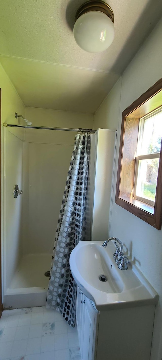 bathroom featuring walk in shower and vanity