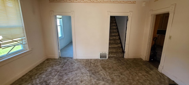 spare room with dark colored carpet