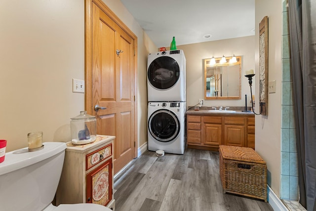 clothes washing area with light wood-type flooring, stacked washer / dryer, and sink