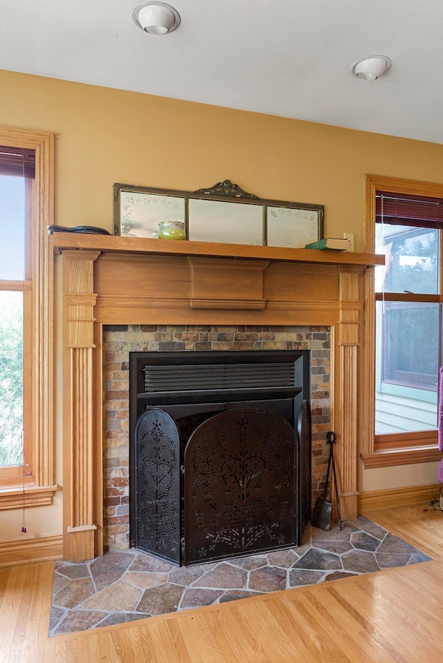 interior details with hardwood / wood-style flooring and a stone fireplace