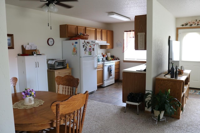 kitchen featuring brown cabinets, a toaster, ceiling fan, white appliances, and under cabinet range hood