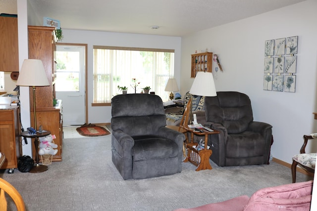 carpeted living area featuring baseboards