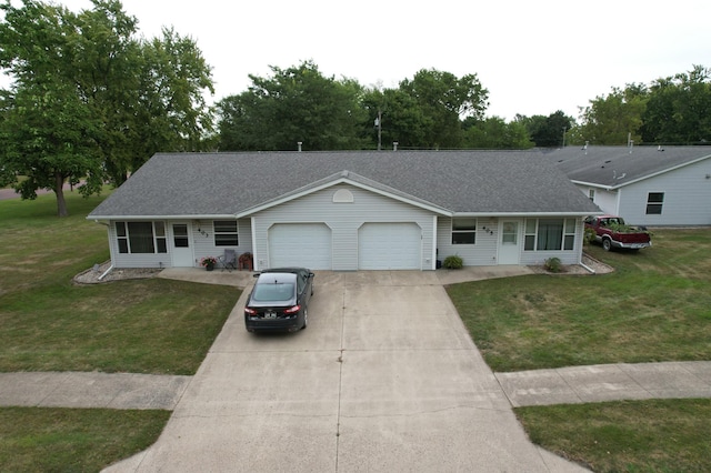 ranch-style house with concrete driveway, a shingled roof, a garage, and a front lawn