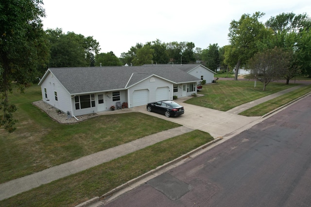 view of front of house featuring concrete driveway, an attached garage, a front lawn, and a shingled roof