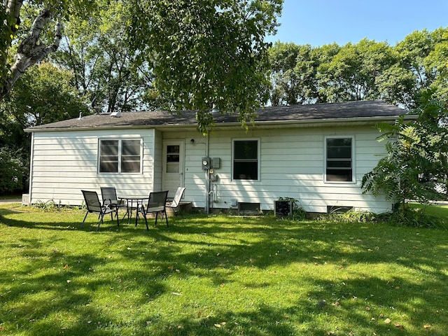 rear view of house featuring a lawn