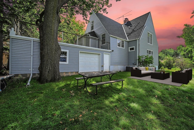 back house at dusk with an outdoor living space, a yard, and a garage