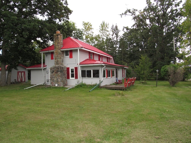 back of property featuring a storage shed, a lawn, and a wooden deck