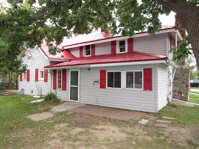 view of front of house featuring a front lawn and metal roof