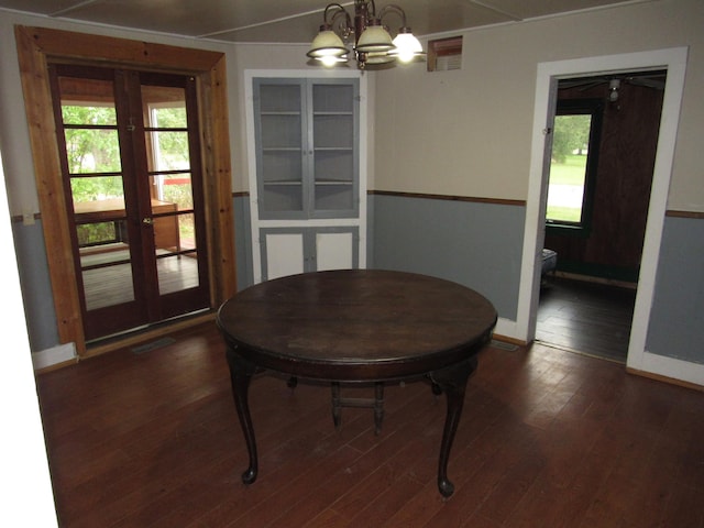 dining area featuring an inviting chandelier, dark hardwood / wood-style floors, and french doors