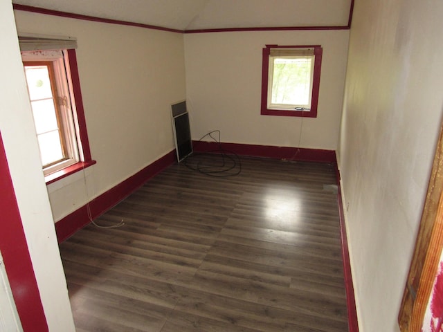 empty room with ornamental molding and dark hardwood / wood-style floors