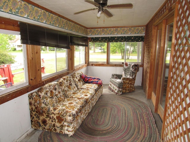 sunroom with plenty of natural light, a ceiling fan, and an outdoor hangout area