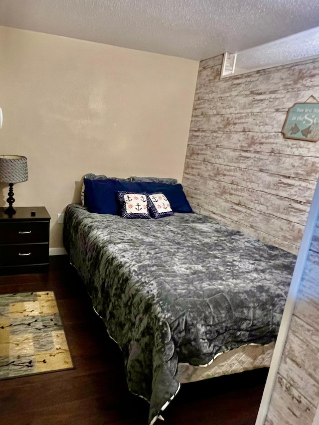 bedroom featuring a textured ceiling and dark wood-type flooring