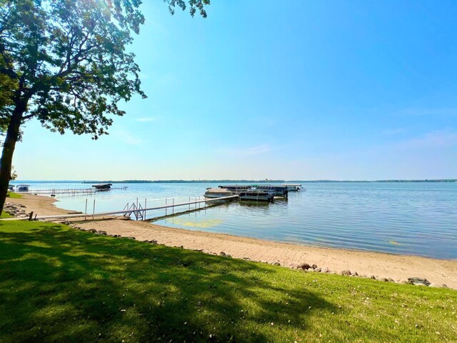 view of dock featuring a lawn and a water view