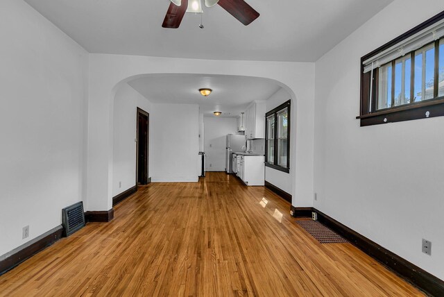 empty room featuring ceiling fan, light hardwood / wood-style floors, and a healthy amount of sunlight