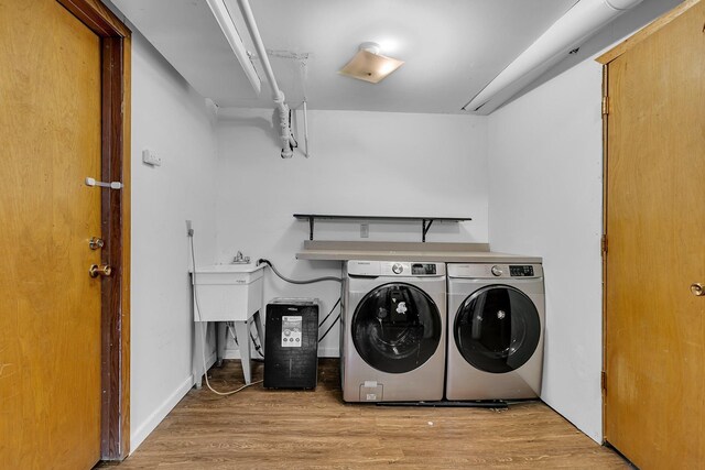 washroom featuring washing machine and dryer and light wood-type flooring