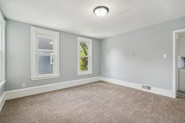 carpeted empty room featuring a textured ceiling