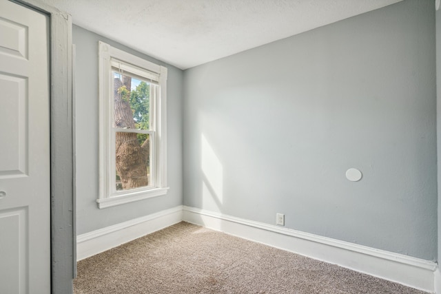 carpeted spare room featuring a textured ceiling