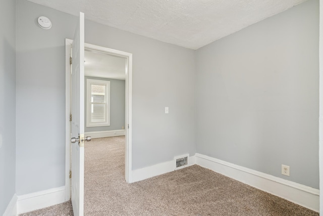 interior space featuring a textured ceiling and carpet floors