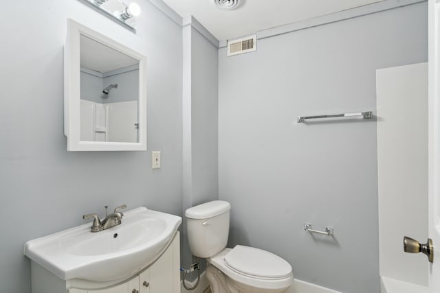 bathroom featuring walk in shower, toilet, and vanity