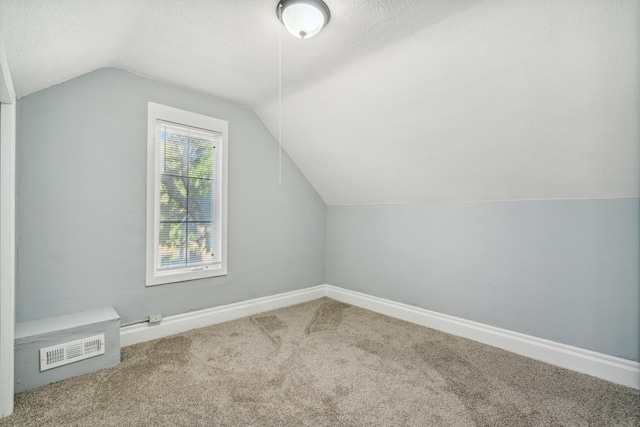 bonus room featuring a textured ceiling, carpet, and vaulted ceiling