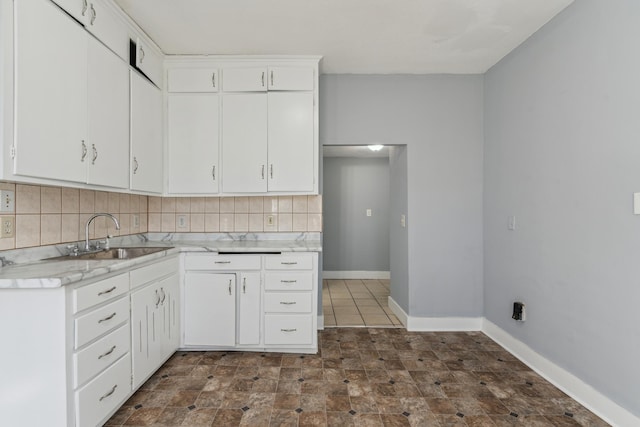 kitchen featuring white cabinets, tasteful backsplash, and sink