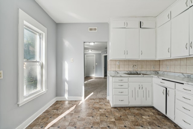 kitchen with sink, white cabinetry, and a healthy amount of sunlight