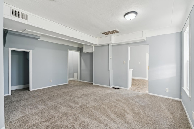 unfurnished bedroom featuring light colored carpet and a textured ceiling