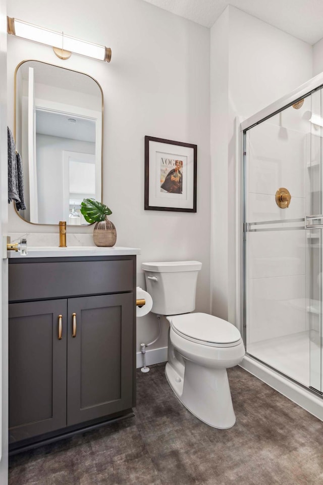 bathroom with a shower with door, vanity, and toilet