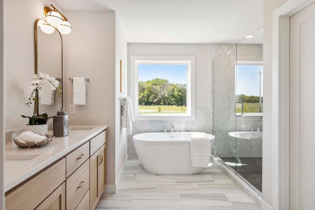 bathroom featuring vanity, separate shower and tub, and a textured ceiling