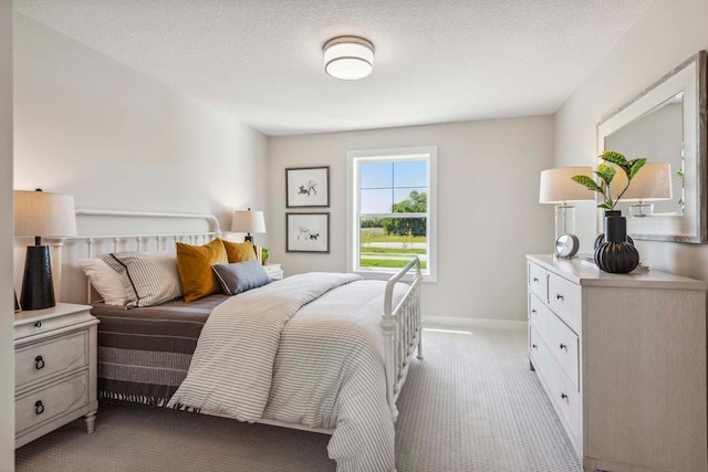 bedroom featuring light carpet and a textured ceiling