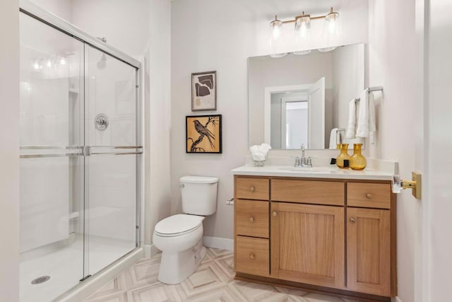 bathroom with vanity, toilet, and a shower with door