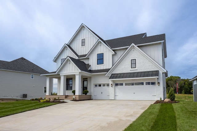 modern inspired farmhouse with a porch, a front lawn, and a garage