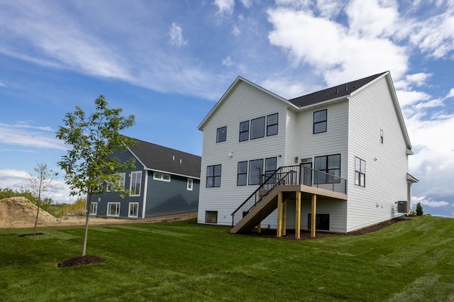 back of house with central air condition unit, a deck, and a yard