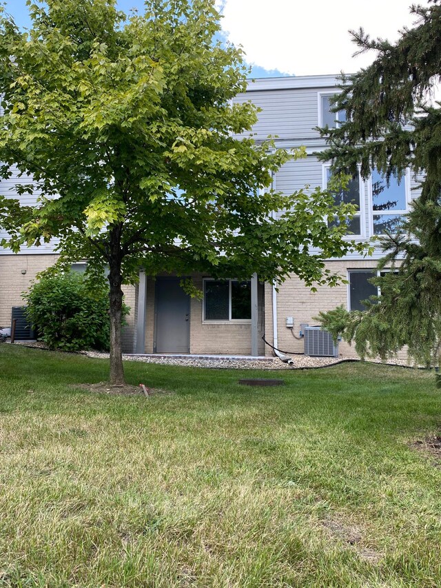 view of front of house featuring a front yard and central AC unit