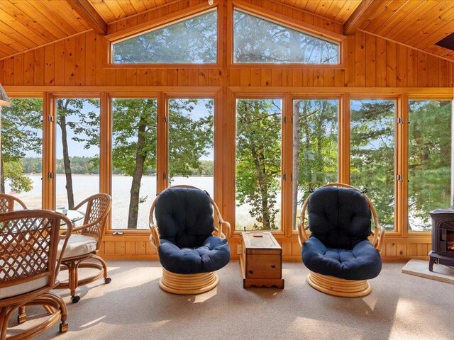 sunroom / solarium featuring a water view, plenty of natural light, and vaulted ceiling with beams