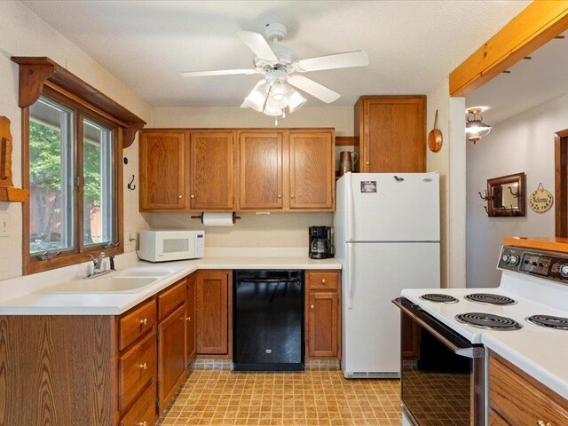 kitchen with white appliances, sink, and ceiling fan