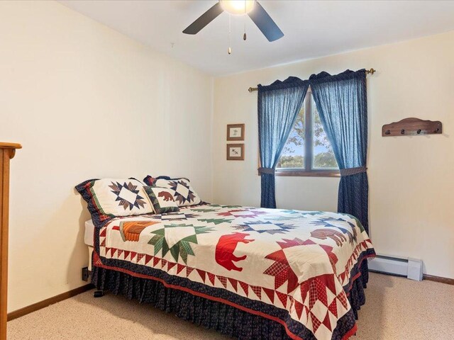 carpeted bedroom with ceiling fan and baseboard heating