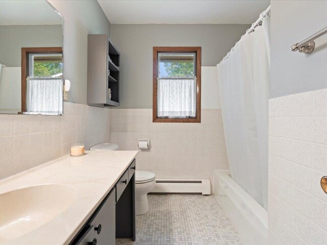 full bathroom with toilet, baseboard heating, tile patterned floors, tile walls, and vanity