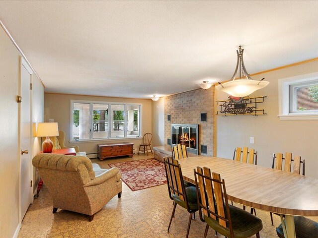 dining area with ornamental molding and a fireplace