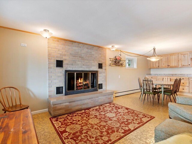 living room featuring baseboard heating, a fireplace, and ornamental molding