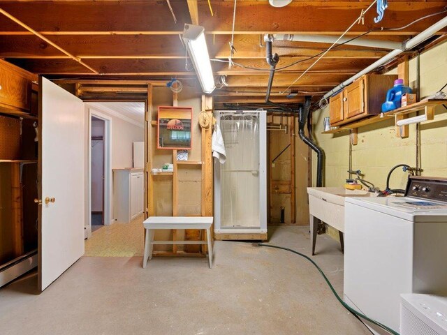 basement featuring washer / dryer, a baseboard radiator, and sink