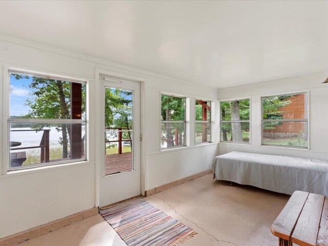 bedroom with access to exterior, breakfast area, and a water view