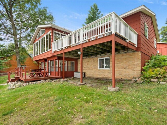 rear view of house featuring a deck and a yard