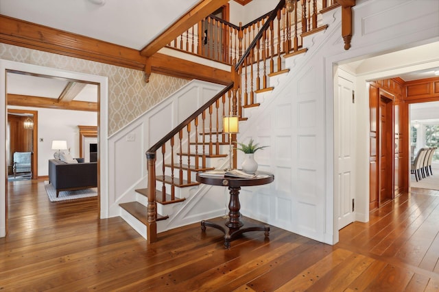 stairway with beam ceiling and hardwood / wood-style flooring