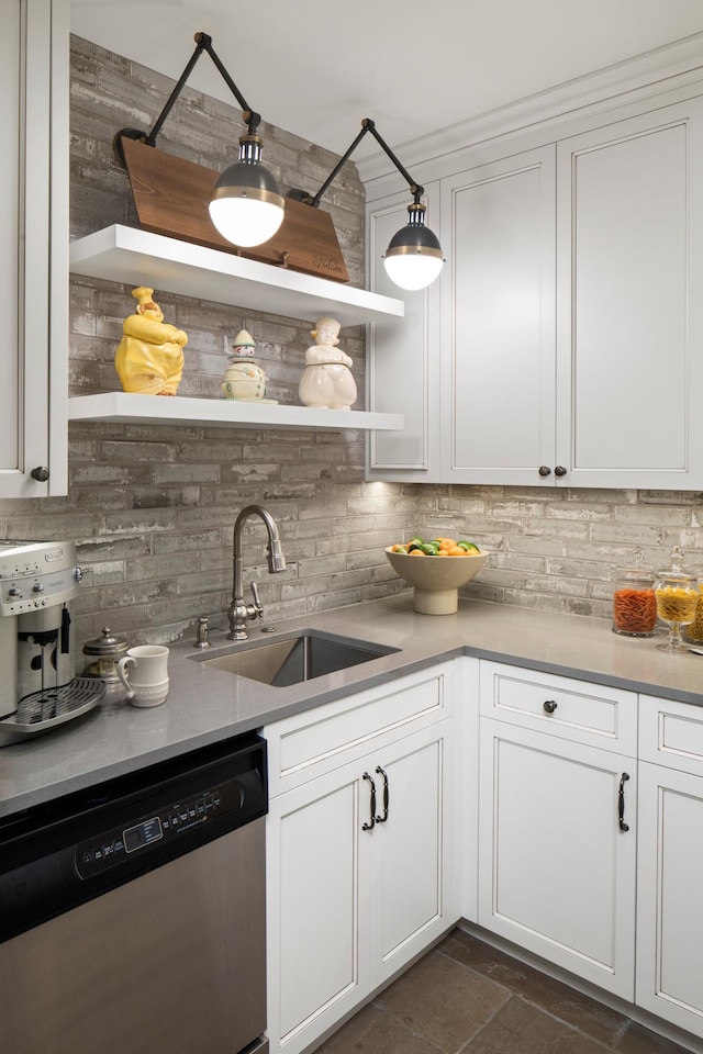 kitchen featuring white cabinetry, decorative backsplash, pendant lighting, stainless steel dishwasher, and sink