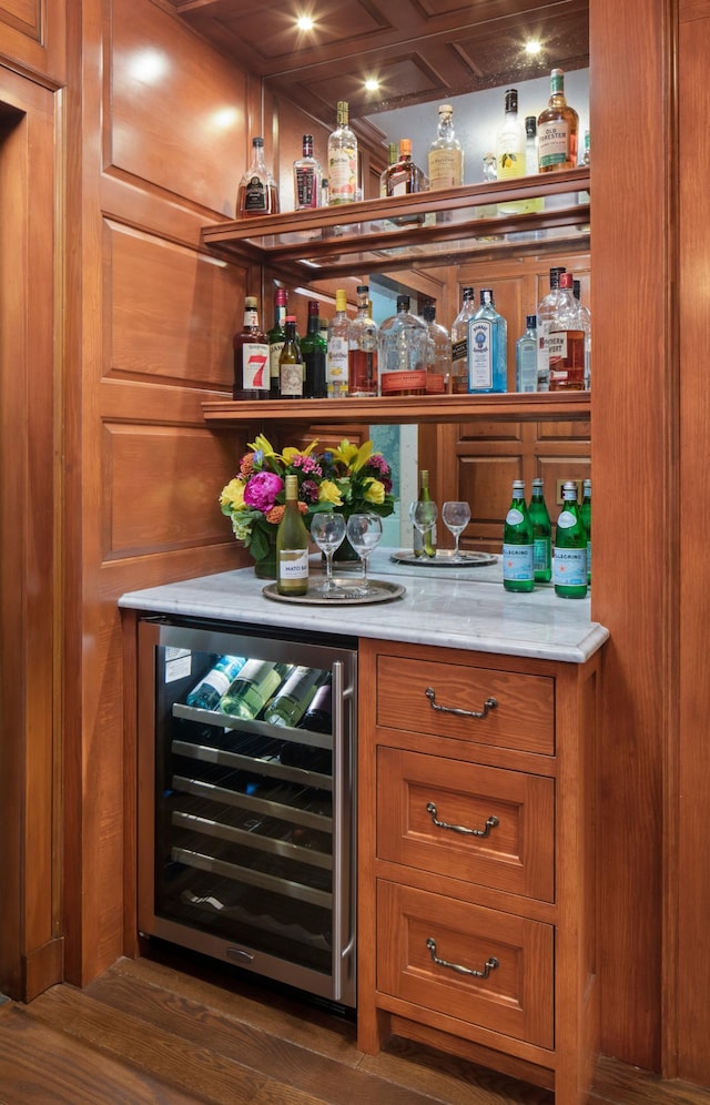 bar with coffered ceiling, dark wood-type flooring, beverage cooler, and wooden walls