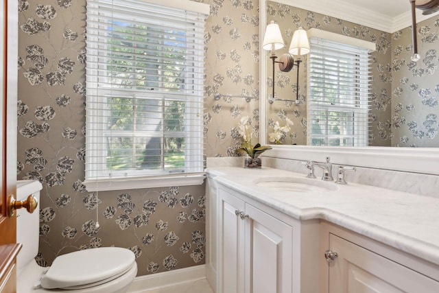 bathroom featuring toilet, vanity, and ornamental molding