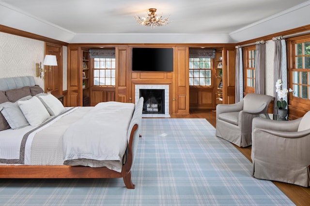 bedroom featuring a fireplace, multiple windows, hardwood / wood-style floors, and vaulted ceiling