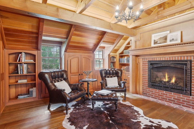 living area with hardwood / wood-style floors, wood ceiling, built in shelves, vaulted ceiling with beams, and wooden walls