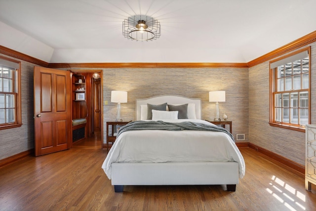 bedroom with lofted ceiling, hardwood / wood-style floors, and multiple windows